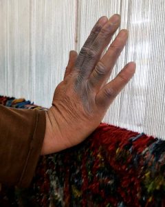 Photograph of weavers hand called Invisible Hands by Armaghan Fatemi.